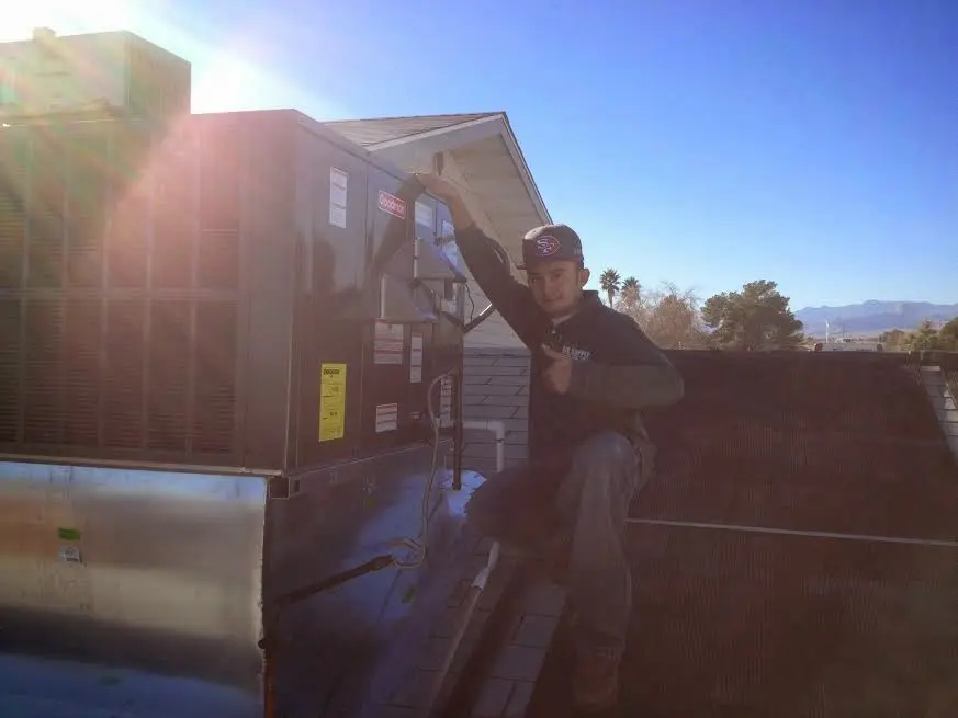 HVAC technician performing AC Tune-Up on a rooftop unit in Roseland