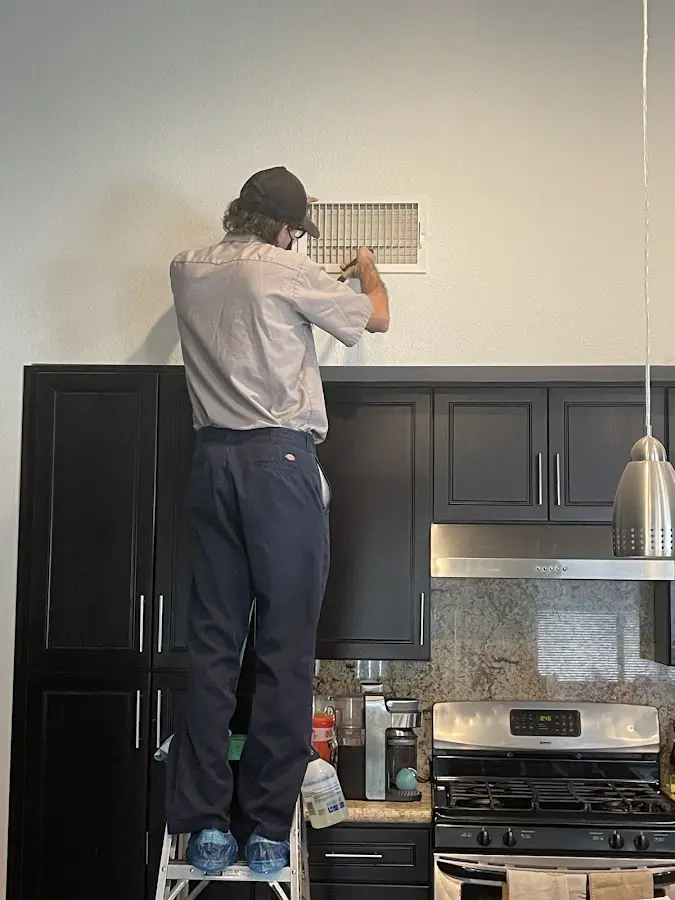 Technician inspecting an air vent during HVAC service in Roseland